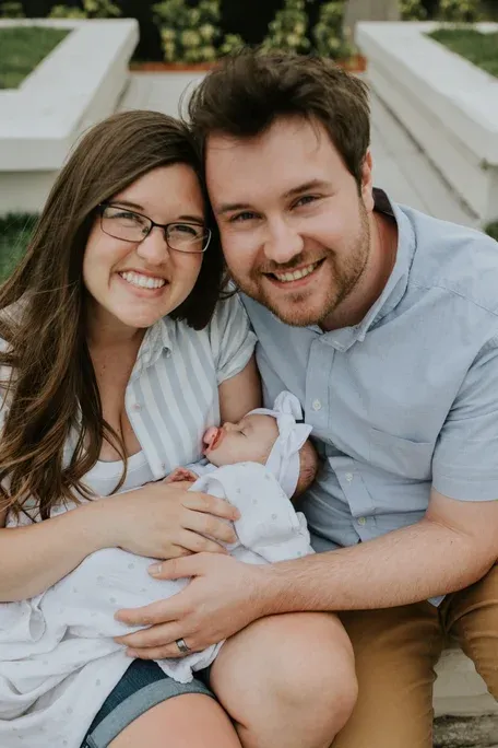 New parents with newborn baby girl sleeping in moms arms
