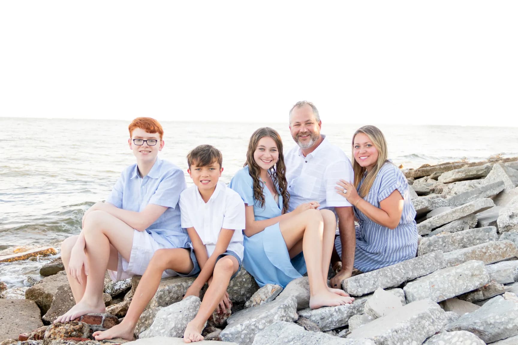 Family of five sitting on rocks